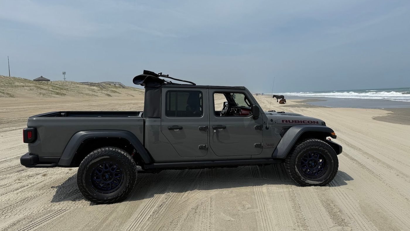 Real photo: a gray Beach 4x4 Jeep Gladiator Rubicon parked on the 4x4 beach.